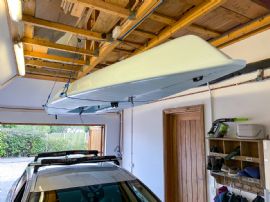 A Laser Dinghy being stored against a garage roof using Skydock